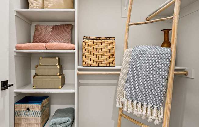 A ladder is leaning against a wall with a blanket hanging on it.