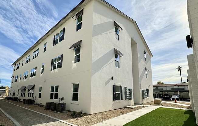 A white building with a green lawn in front.