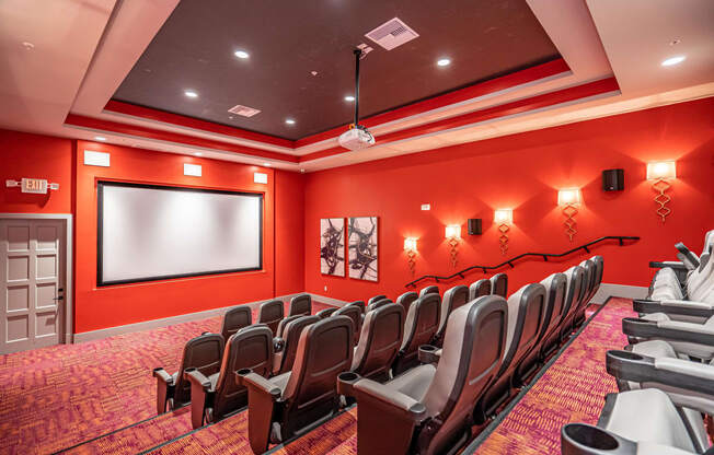 a room with a projector screen and chairs