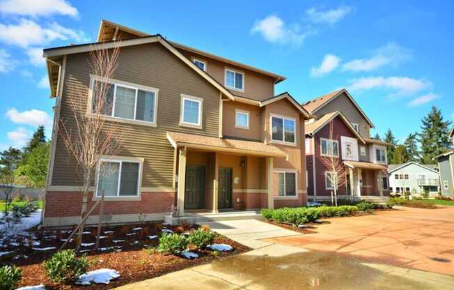 A large house with a brown and beige exterior and a red roof.