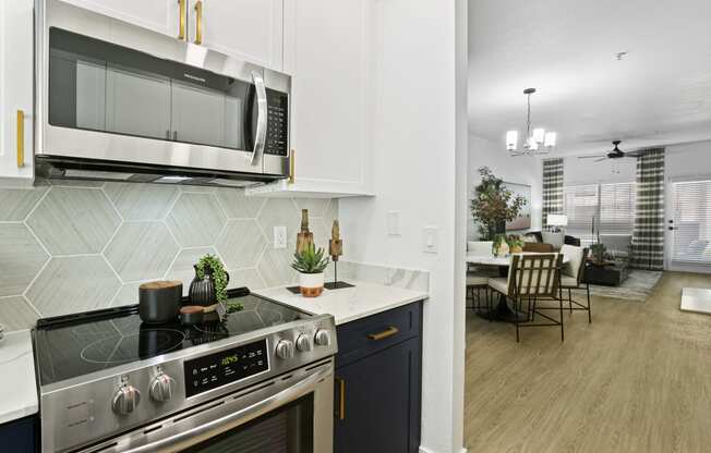 a kitchen and living room with a stove and a microwave