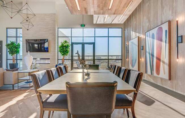 A modern dining room with a long table and chairs.