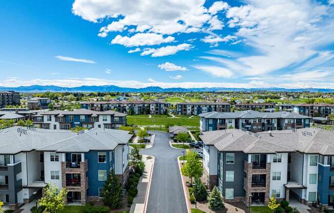 an aerial view of rows of apartment buildings with a road in the middle at Arbour Commons, Colorado, 80023