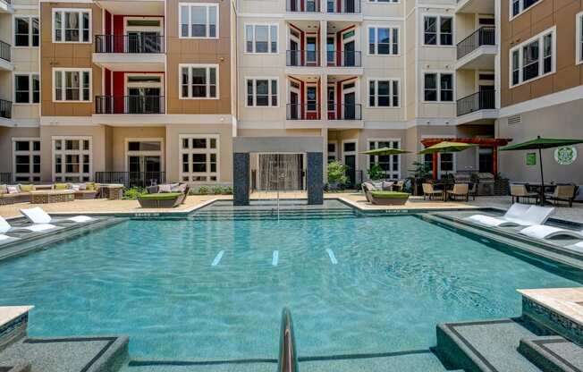 a large swimming pool in front of an apartment building