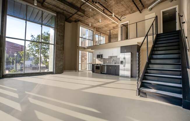 a large open space with a staircase and a kitchen