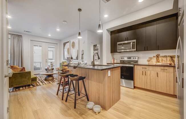 a kitchen and living room with a bar and stools