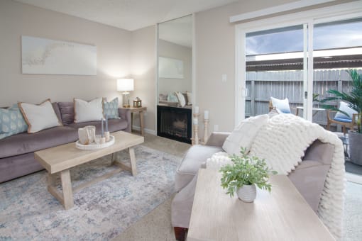 Model apartment living room with a couch and a coffee table and patio door