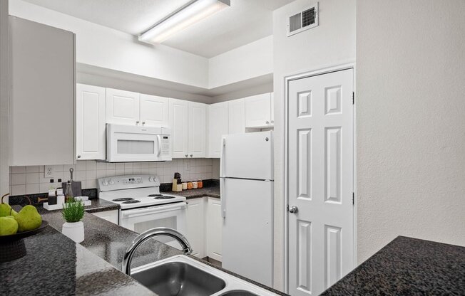 a kitchen with white cabinets and white appliances