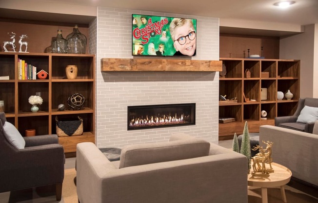 Community room with comfortable seating, tv and fireplace at The McMillan.