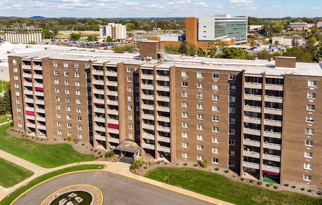 a large apartment building with many balconies and a parking lot in front of it