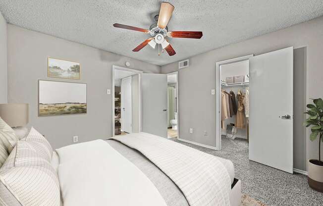a bedroom with a bed and a ceiling fan at Legacy Apartments in Plano, TX