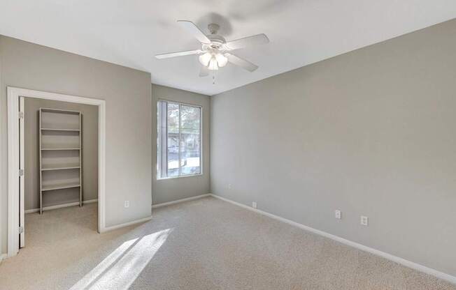 A room with a ceiling fan and a window.
