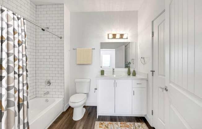 a white bathroom with a shower toilet and sink