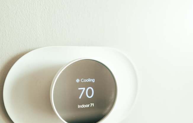 a digital thermostat on a white wall