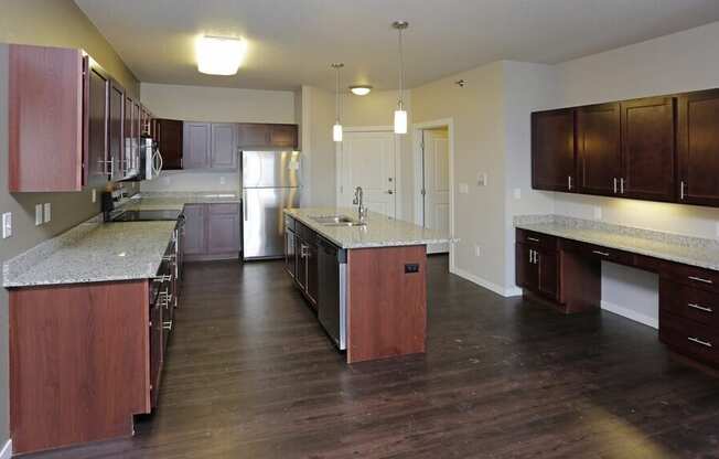 A kitchen with dark wood floors and a marble countertop.