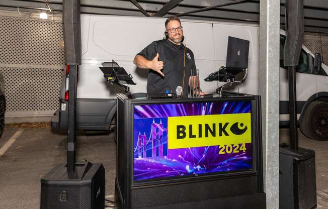 a man giving a thumbs up in front of a blinko van with a