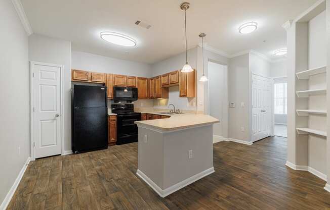 a kitchen with an island and a black refrigerator