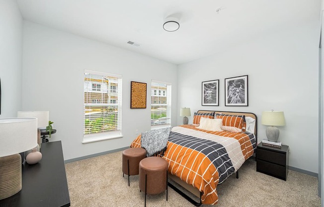 a bedroom with a bed and two windows