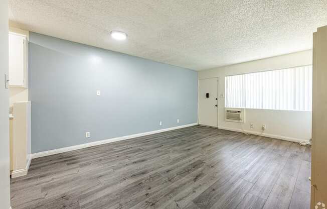 A room with a light blue wall and wooden flooring.