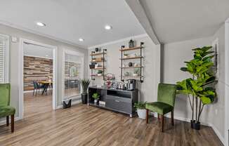 a living room with white walls and wood floors and a black entertainment center