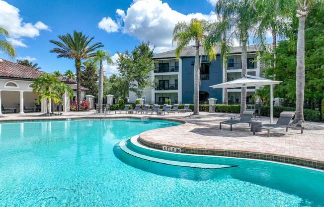 a pool with palm trees at Verano apartments