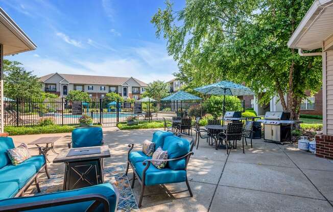 a patio with blue chairs and tables and umbrellas