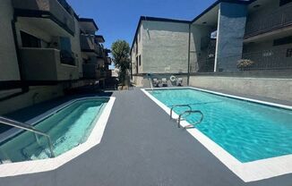 a swimming pool is next to an apartment building