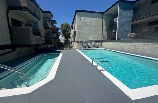 a swimming pool is next to an apartment building