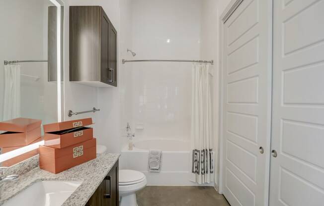 a white bathroom with a shower and a sink and a toilet
