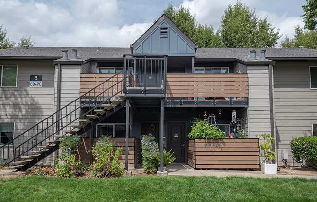An apartment building with a grey facade and a balcony with a railing at Pepperwood Apartments, California, 95661