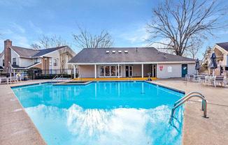 A large swimming pool in front of a building with a yellow line on the edge.