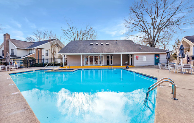 A large swimming pool in front of a building with a yellow line on the edge.