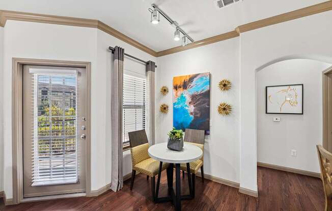 A dining room with a table and chairs.