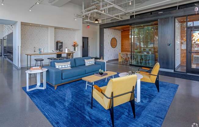 a lobby with blue couches and chairs and a blue rug