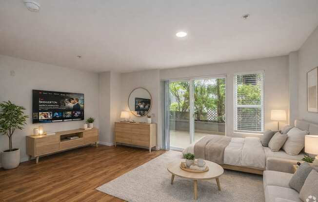 A modern living room with a flat screen TV, a sofa, a coffee table, and a potted plant.