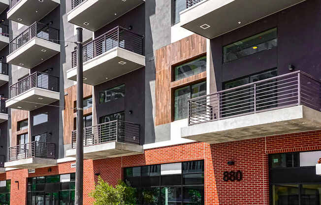 A modern building with balconies and a brick facade.