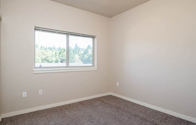 a bedroom with a large window and carpet