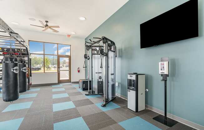 a fitness room with cardio equipment and a flat screen tv