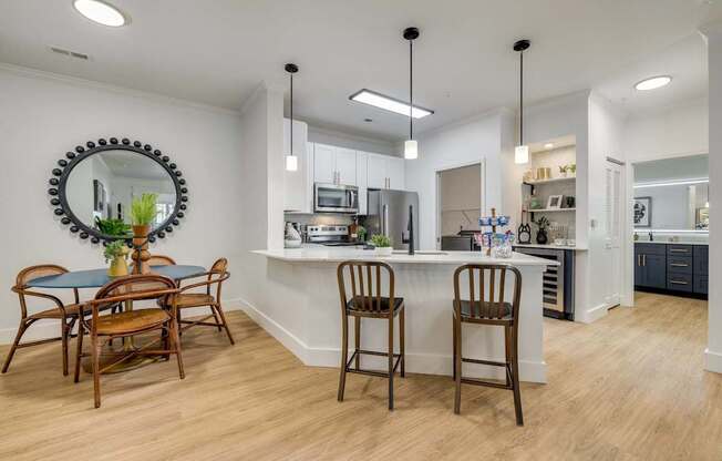 A kitchen with a table and chairs.