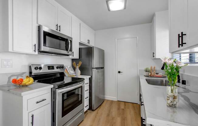 a kitchen with white cabinetry and stainless steel appliances