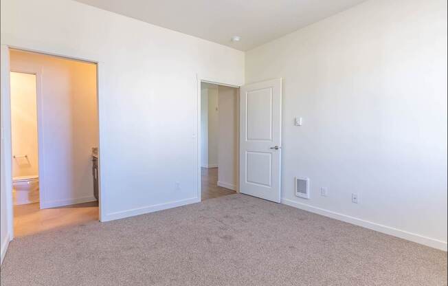A large, empty room with carpeted flooring and white walls at Riverplace Apartment Homes, Independence, OR