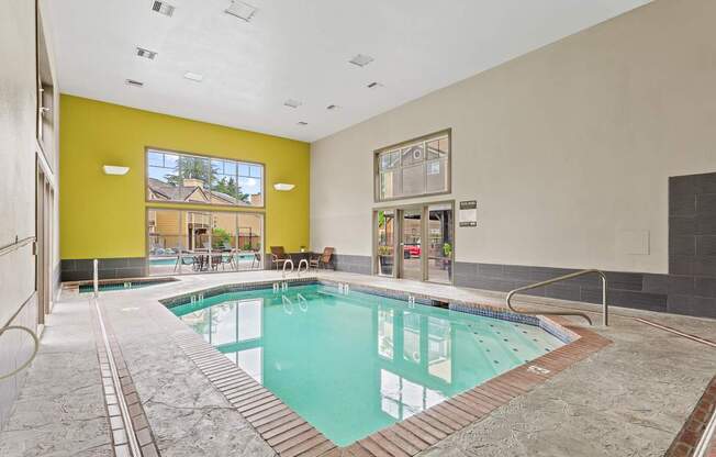 A large indoor swimming pool with a glass wall.