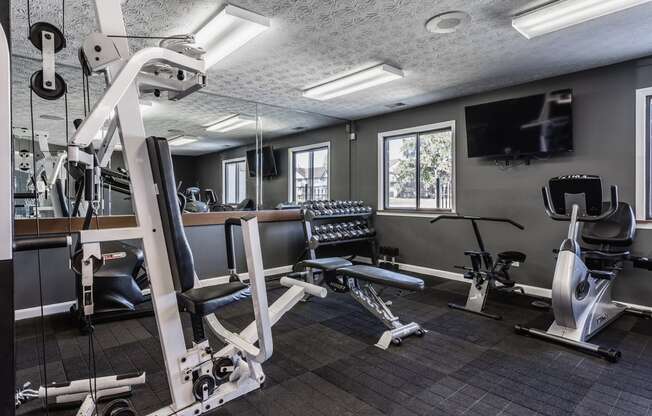 a gym with exercise equipment and a flat screen tv