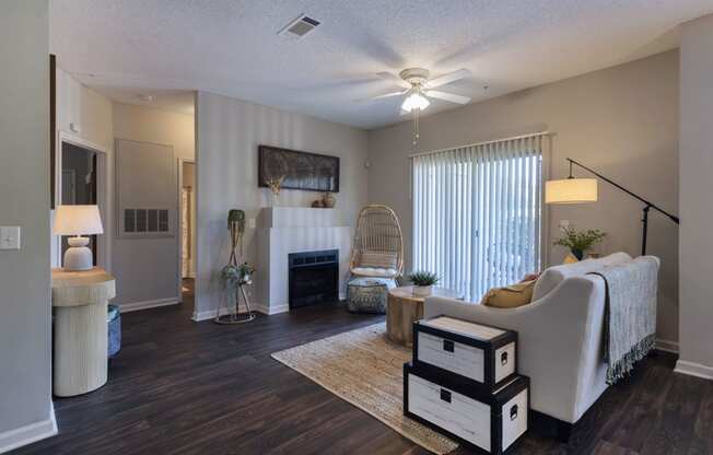 a living room at Seasons at Umstead apartments in Raleigh with a fireplace and a ceiling fan