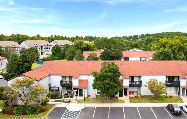 A parking lot in front of a building with a red roof.