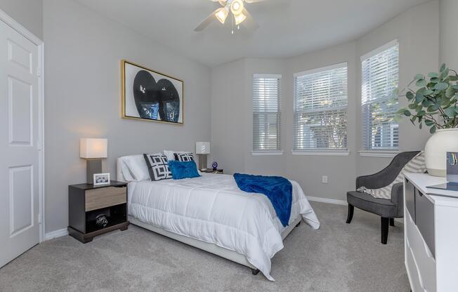 a bedroom with a bed and desk in a room
