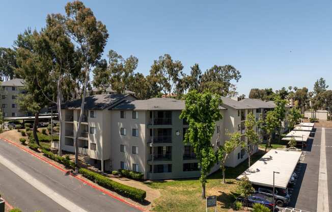 an aerial view of an apartment complex with trees and a street