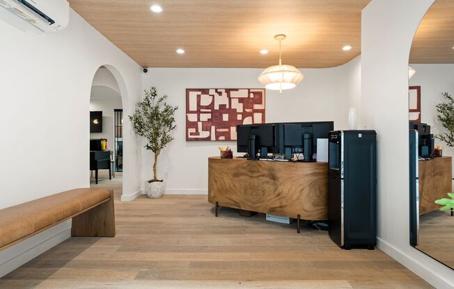 A reception area with a wooden desk and a potted plant.
