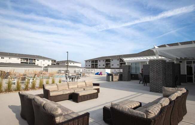 A patio with a white awning and brown furniture.