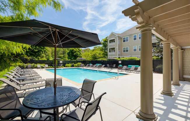 our apartments have a large pool and patio with chairs and umbrellas